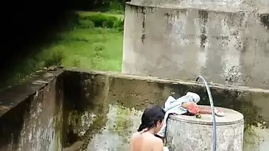Indian village girl bathing near water tank outdoor
